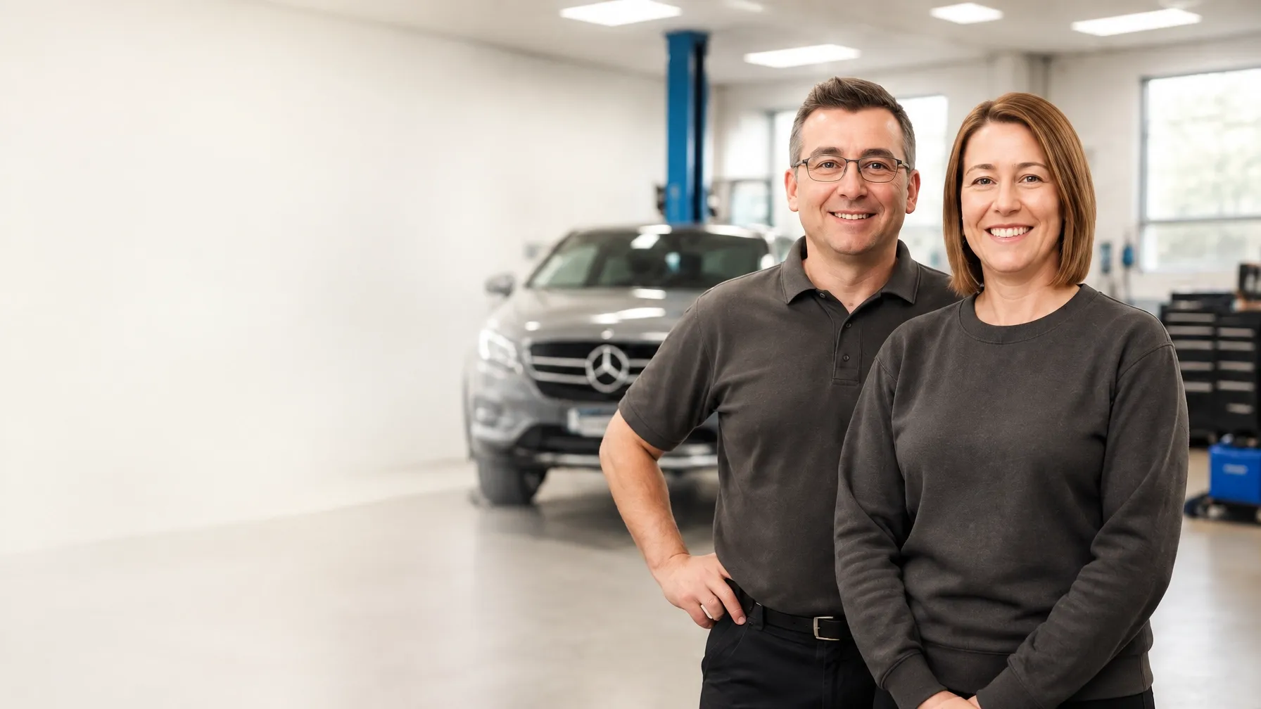 Kevin and Becky standing together in their Mercedes workshop