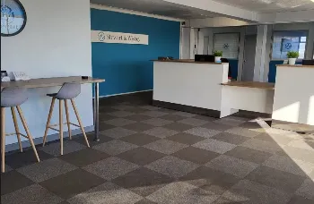 Stewart & Wisbey reception with blue feature wall, white counter and grey bar stools